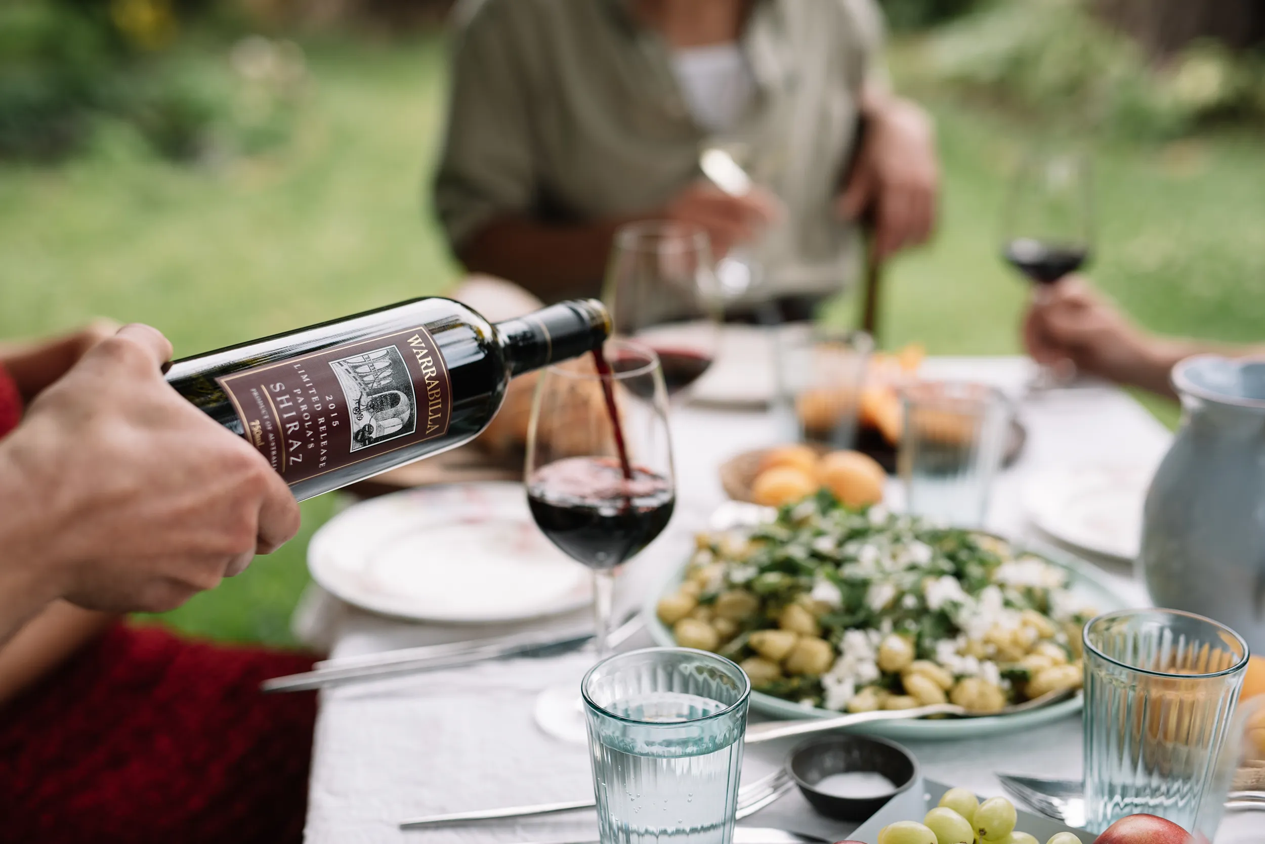 Warrabilla Wine being poured into a glass at a table with a meal